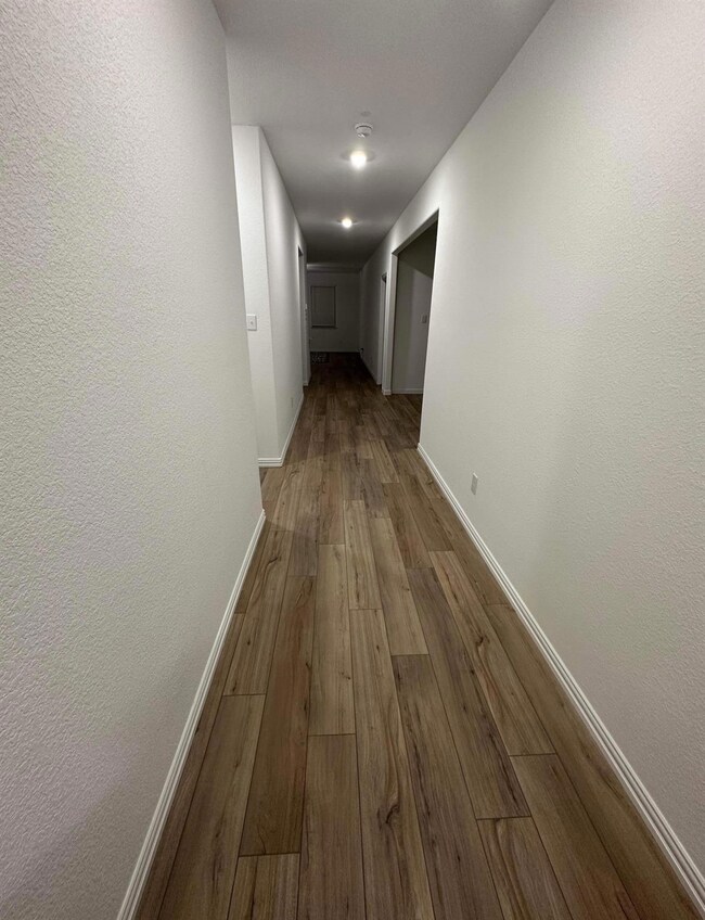 Hallway featuring dark wood finished floors and ba