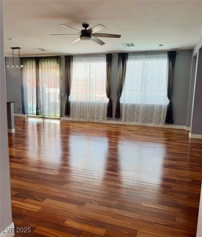 Unfurnished room featuring ceiling fan and wood fi