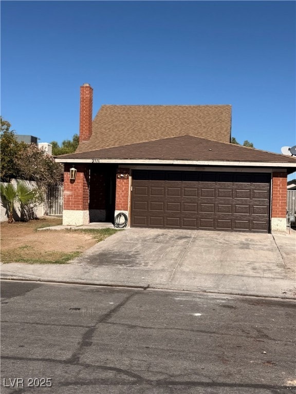 View of front of property featuring brick siding, driveway, a garage, a chimney, and roof with shingles