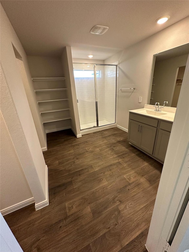 Bathroom with a shower stall, vanity, wood finish