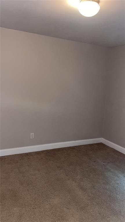 Unfurnished room featuring baseboards and carpet f