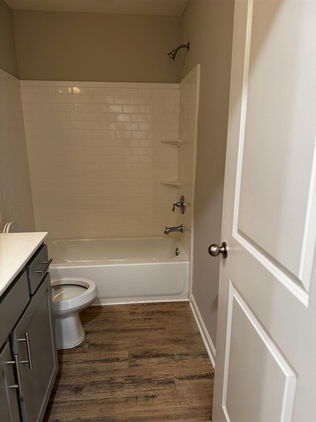 Full bath featuring vanity,  shower combination, and wood finished floors