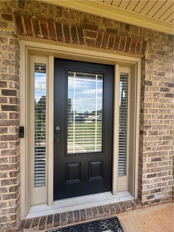 Entrance to property featuring brick siding
