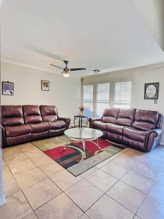 Living area featuring crown molding, light tile pa
