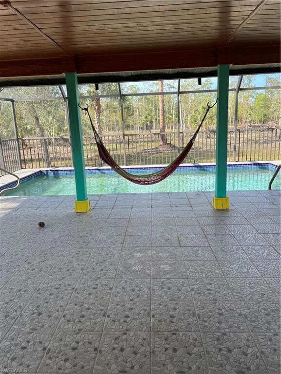 View of swimming pool featuring a lanai