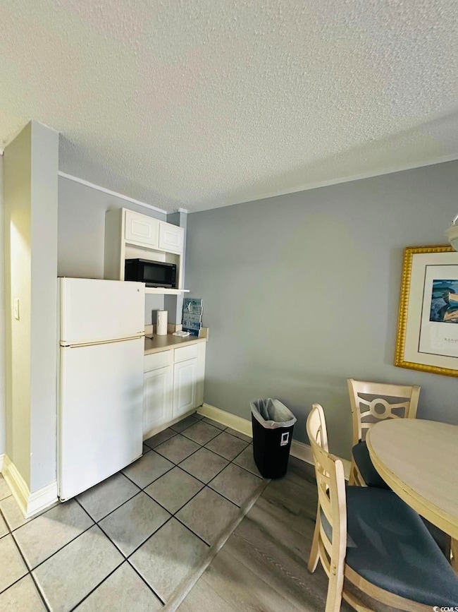 Kitchen featuring tile patterned floors, white ref
