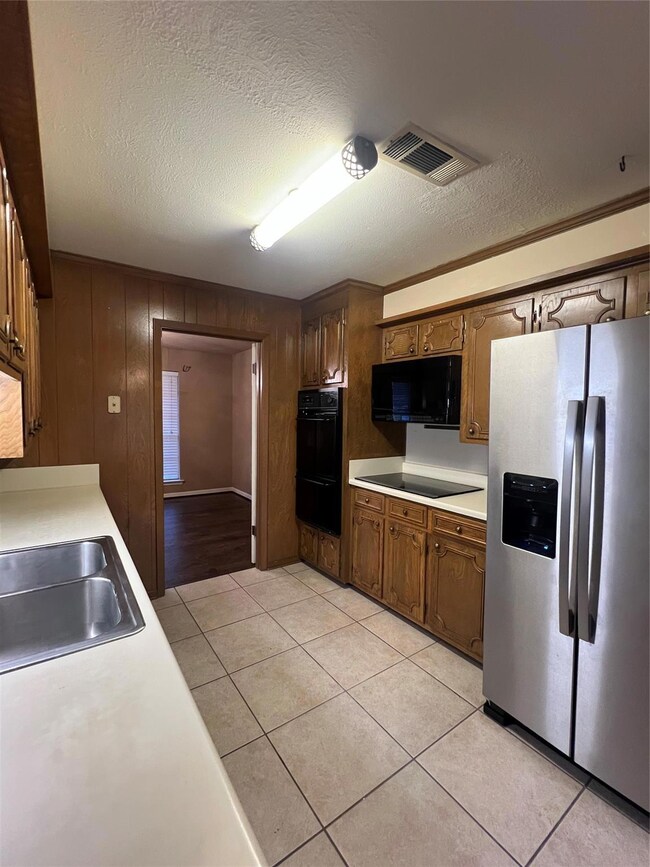 Kitchen with wooden walls, sink, light tile patter