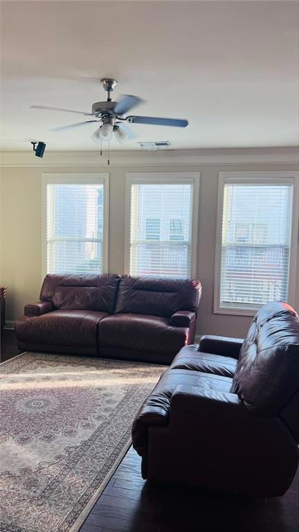 Living room featuring ornamental molding, ceiling fan, and dark hardwood / wood-style floors