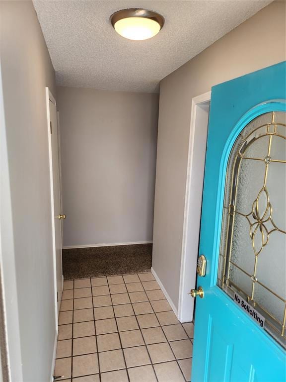 Foyer with light tile patterned flooring, a textur