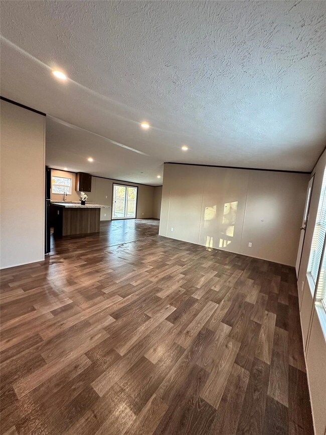 Unfurnished living room featuring dark hardwood / 