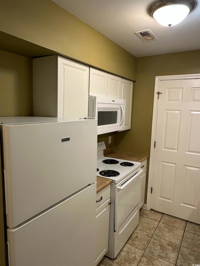 Kitchen with light tile patterned flooring, white 