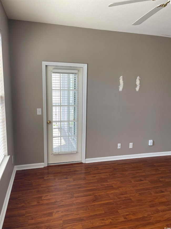 Spare room with baseboards, a ceiling fan, and woo