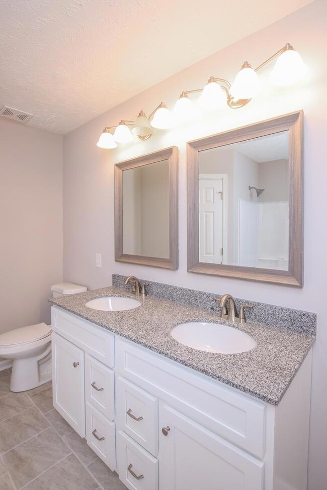 Master bathroom with new cabinets and granite counter tops.  His/her closets.