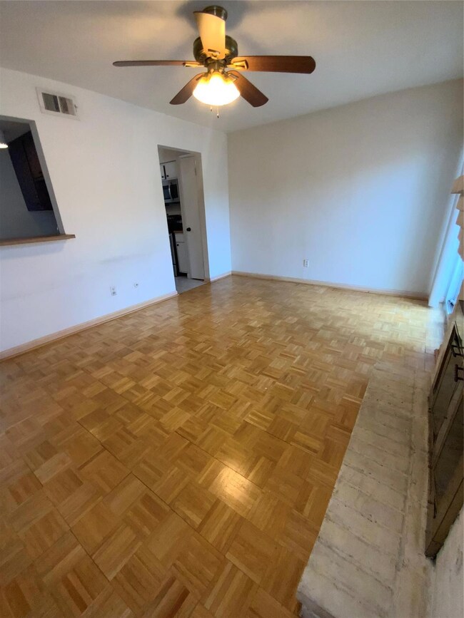 2nd living area with ceiling fan and light parquet