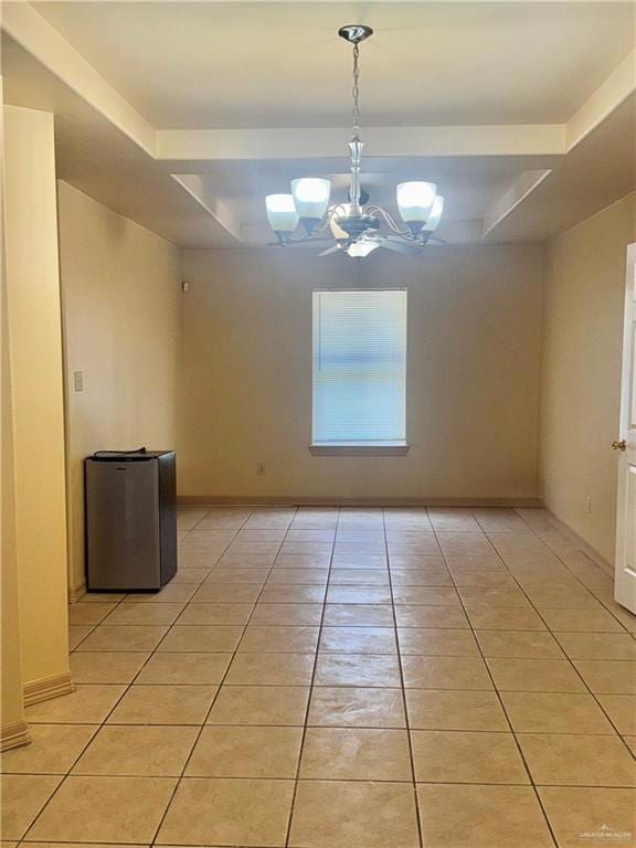 Unfurnished room with light tile patterned floors, a raised ceiling, and a chandelier