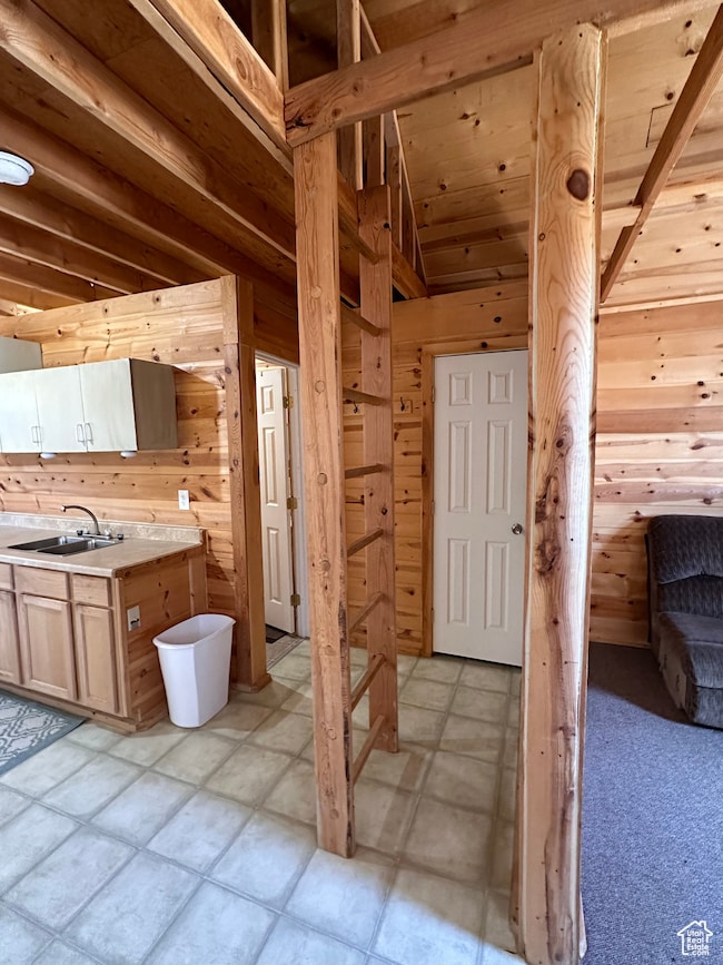 Kitchen featuring wood walls, sink, and light brown cabinets