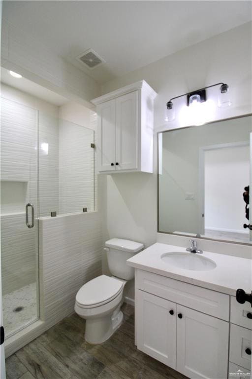 Full bathroom with vanity, dark wood-style flooring, and a stall shower
