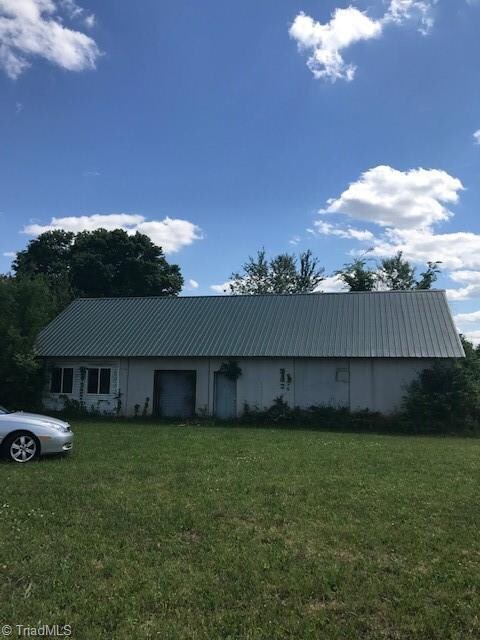 Large concrete building with metal roof.