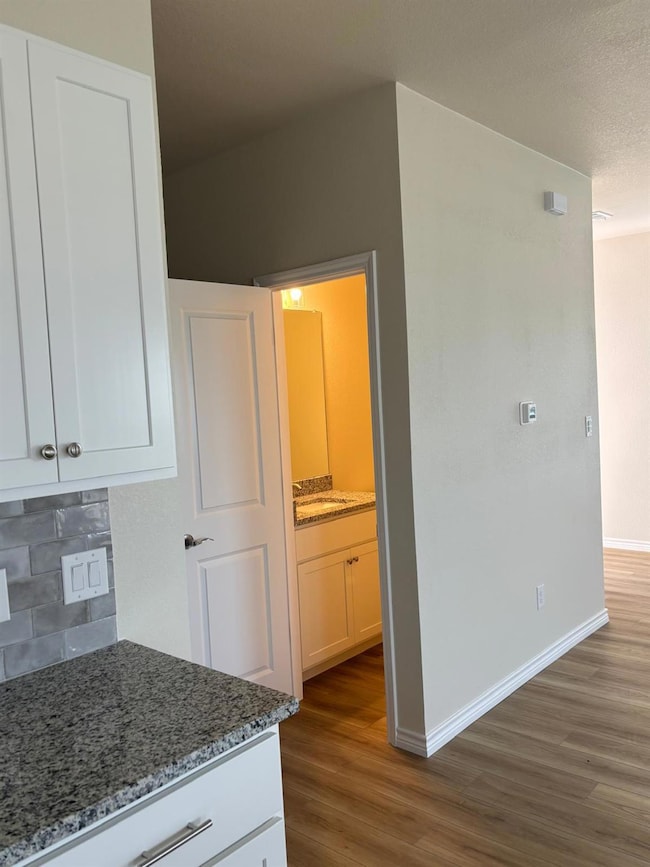 Kitchen with wood finished floors, tasteful backs
