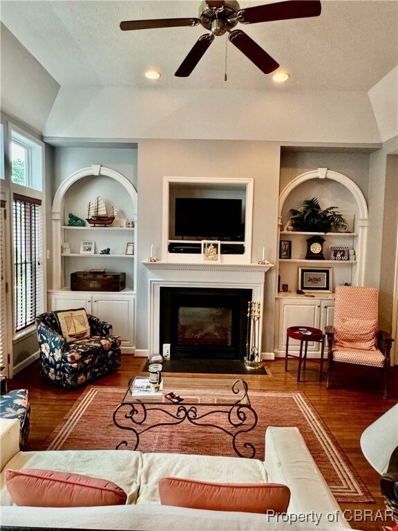 Living room featuring vaulted ceiling, ceiling fan