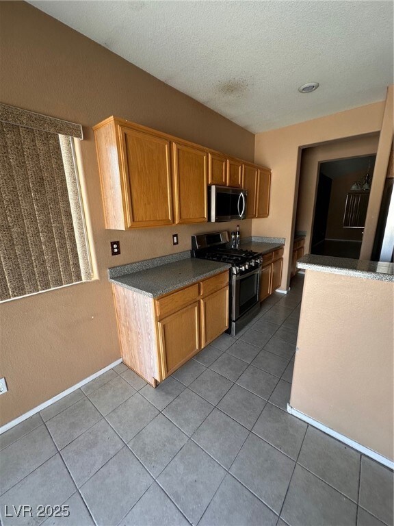 Kitchen featuring stove, tile patterned floors, a