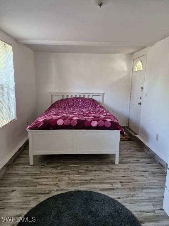 Bedroom with baseboards and light wood finished fl