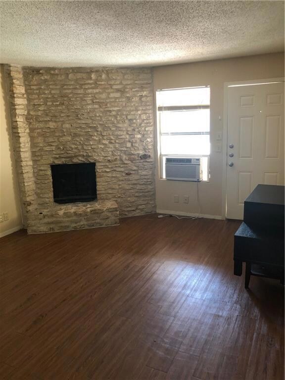 Unfurnished living room featuring a textured ceil