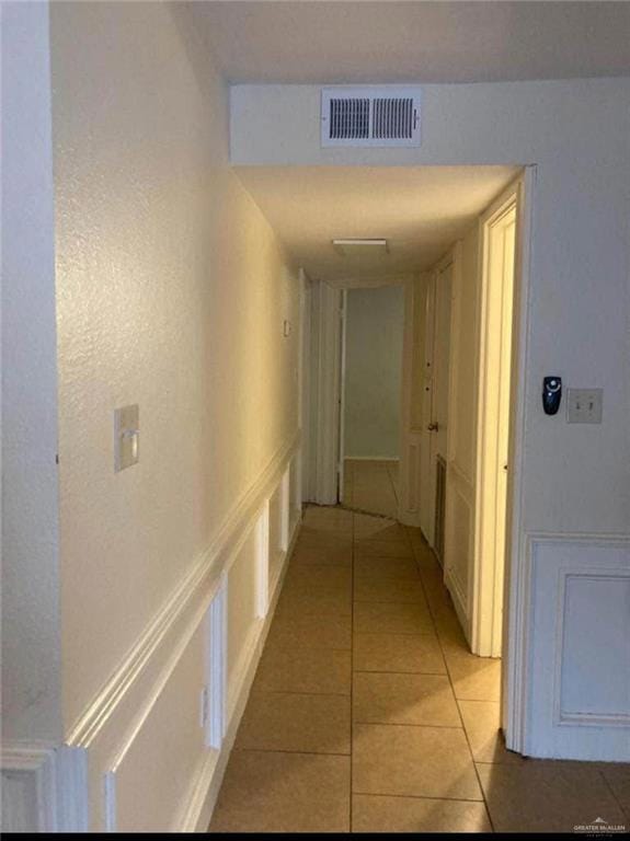Hallway with visible vents and light tile patterned floors