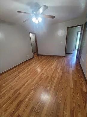 Spare room with wood-type flooring and ceiling fan