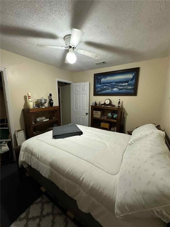 Bedroom featuring a textured ceiling and ceiling fan