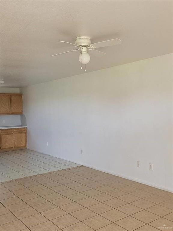 Unfurnished room with light tile patterned floors and ceiling fan