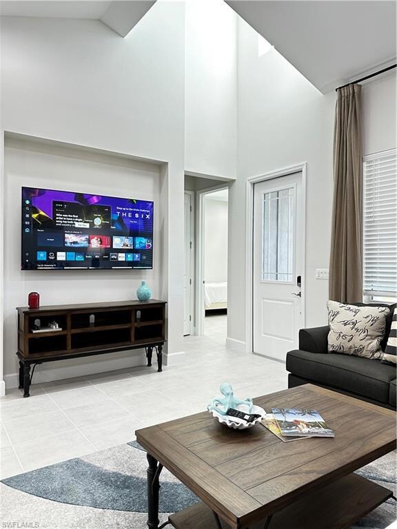 Living room featuring a high ceiling and tile patt