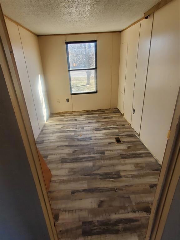 Unfurnished room with a textured ceiling and dark 