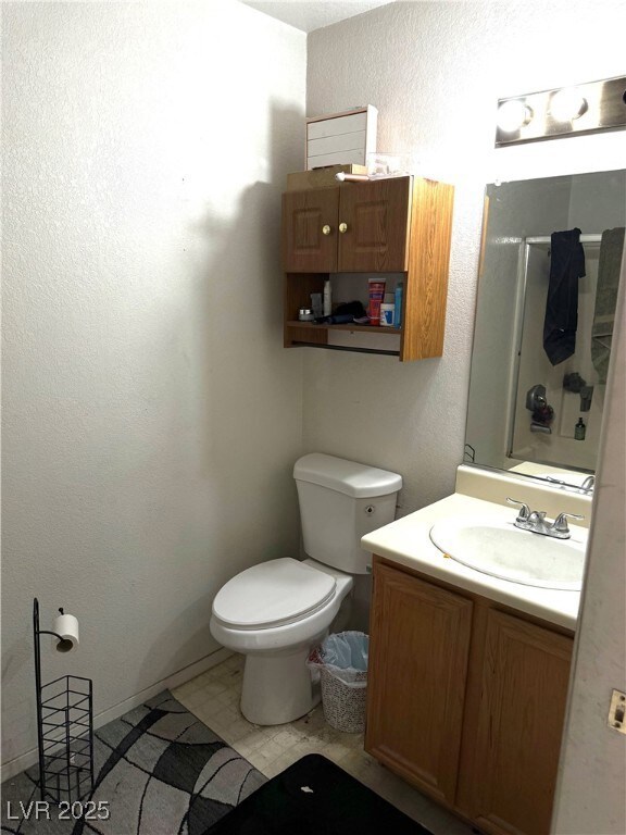 Bathroom featuring vanity, a textured and a shower