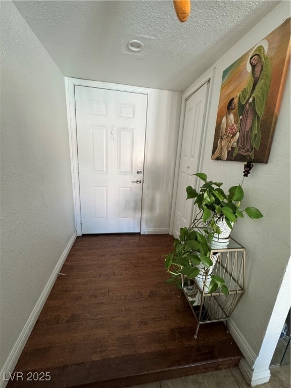 Entryway featuring dark wood finished floors, base