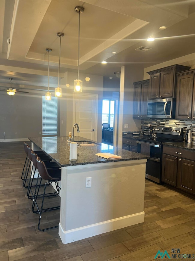 Kitchen featuring appliances with stainless steel finishes, dark stone countertops, tile floor nice cabinetry
