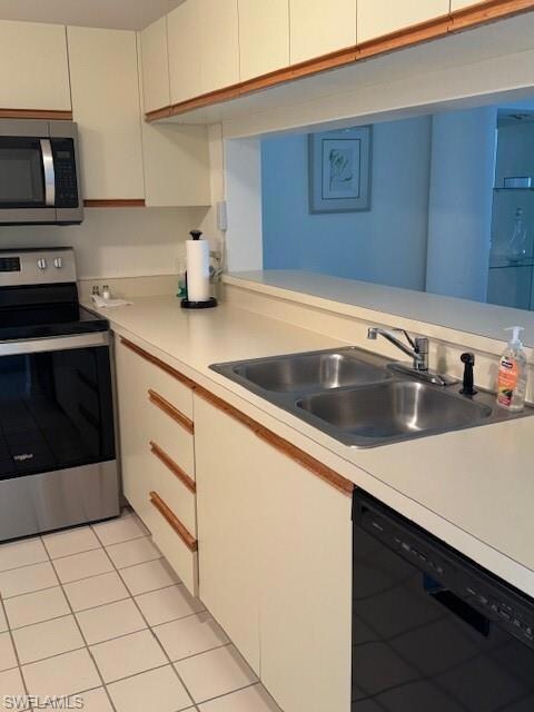 Kitchen with sink, dishwasher, light tile patterne