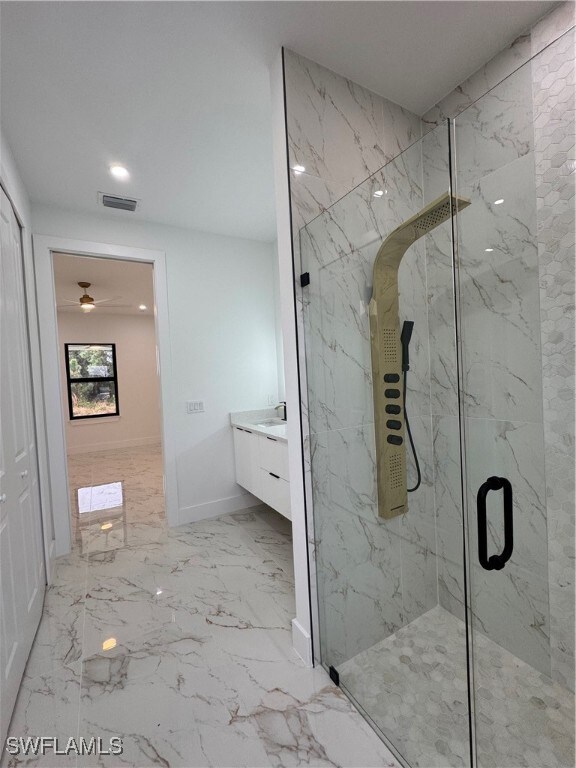 Bathroom featuring a shower with door and vanity