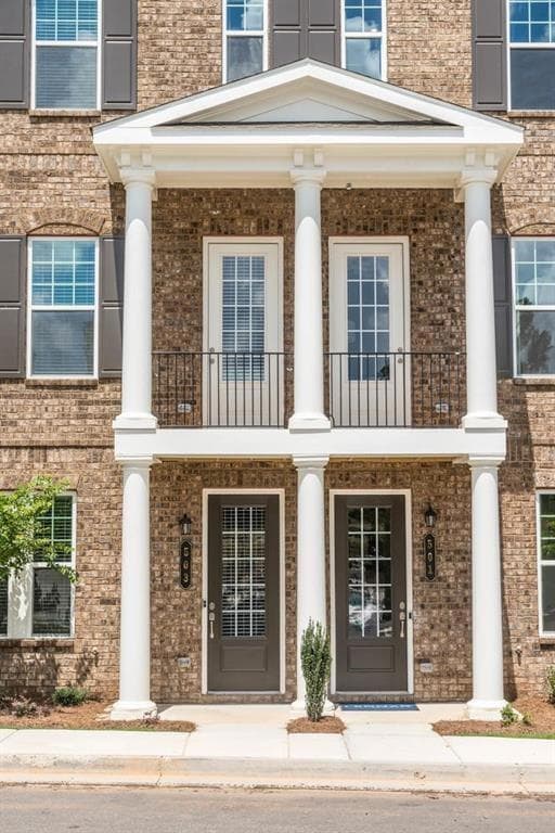 Doorway to property with brick siding and covered porch