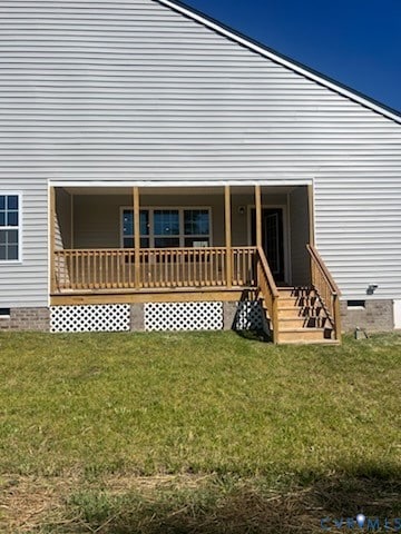 Rear view of house featuring crawl space, a yard, and covered porch