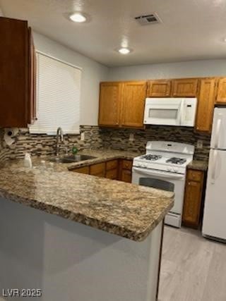 Kitchen featuring white appliances, a peninsula, t