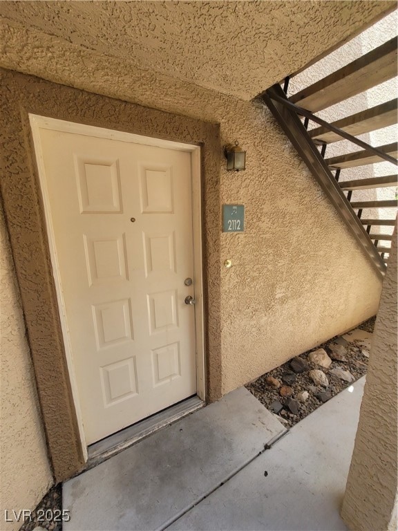 Entrance to property with stucco siding
