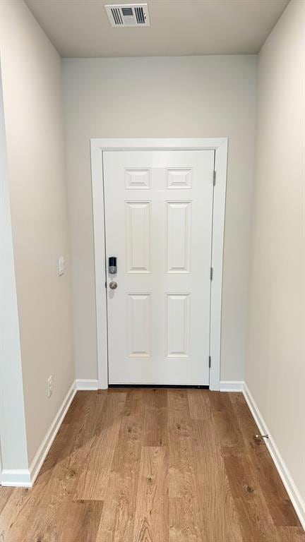Doorway featuring wood finished floors and baseboards