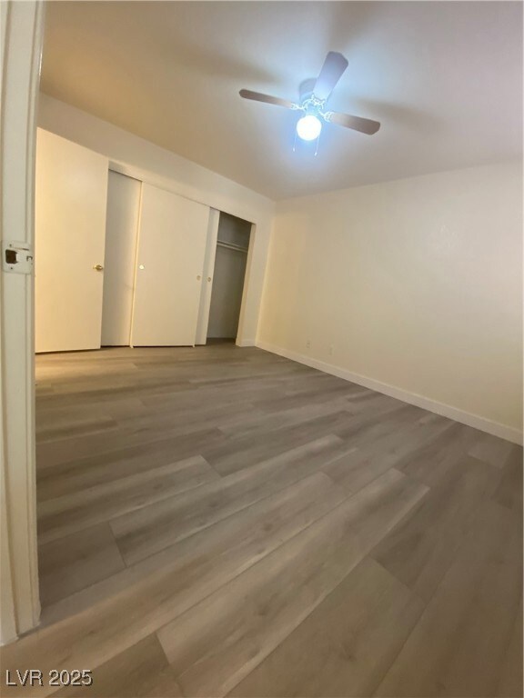 Unfurnished bedroom featuring ceiling fan, wood finished floors, and a closet