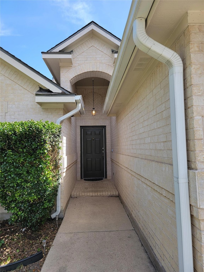 Doorway to property featuring brick siding