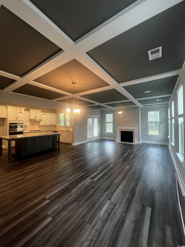 Unfurnished living room featuring dark hardwood / 