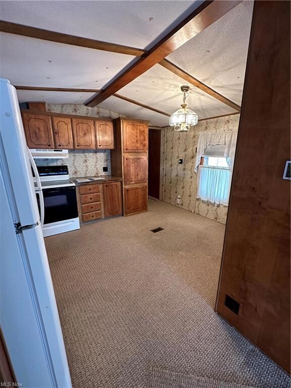 Kitchen with range, light carpet, pendant lighting