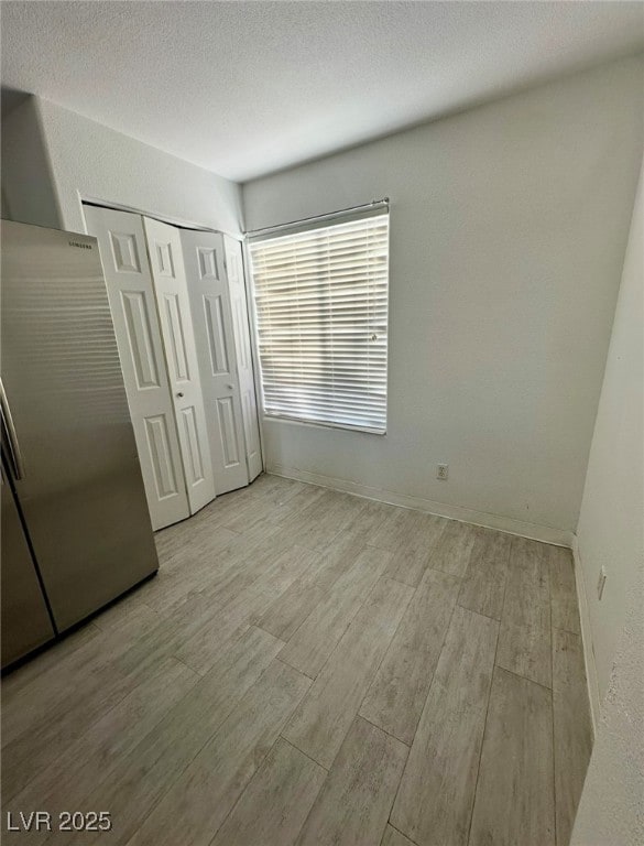 Unfurnished bedroom with wood finished floors, sta