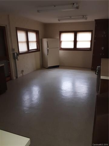 Opposite side of large kitchen with refrigerator.