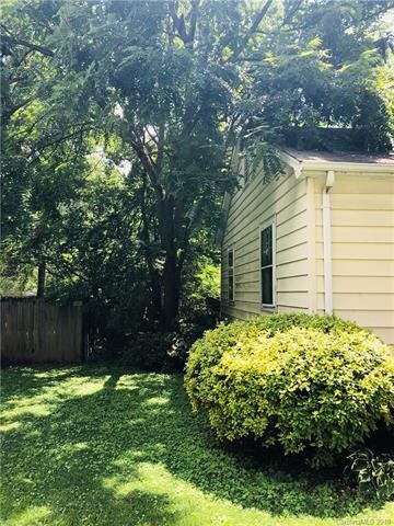 Side view of home - back yard enclosed by fence.